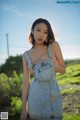 A woman in a denim dress posing for the camera.