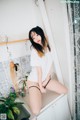 A woman sitting on top of a bathtub in a bathroom.