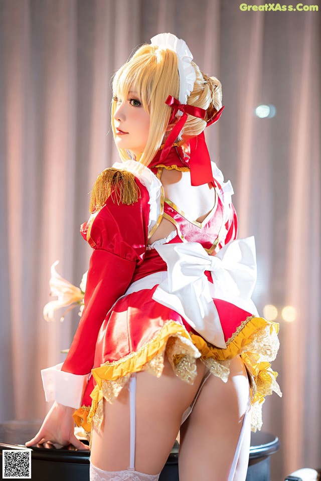 A woman in a red and white dress is posing for a picture.