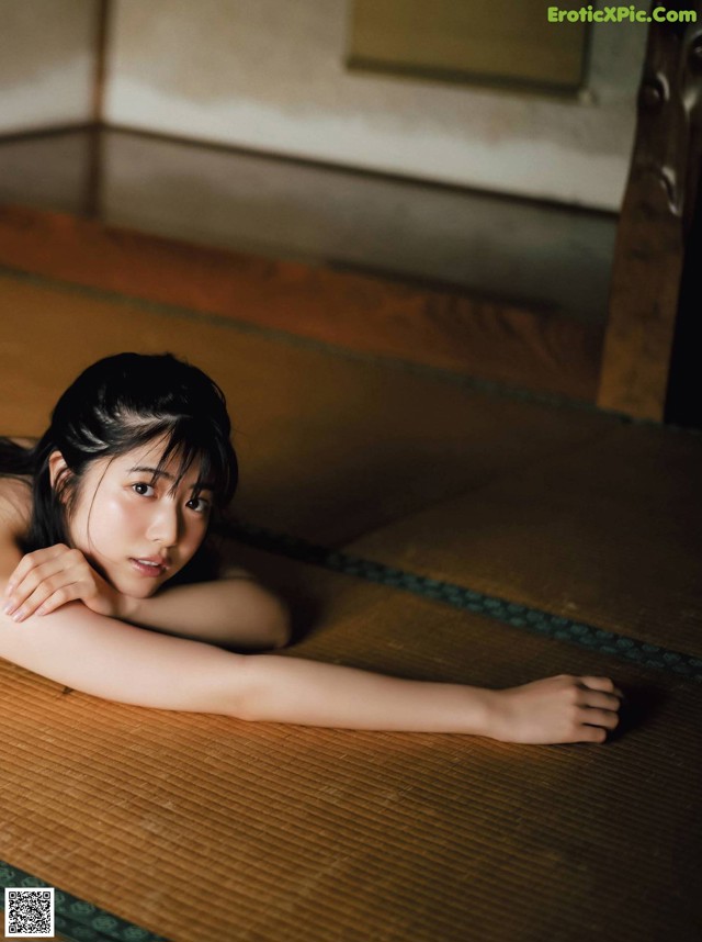 A woman laying on a tatami mat in a room.