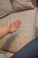 A person sitting on a couch with their hand outstretched.